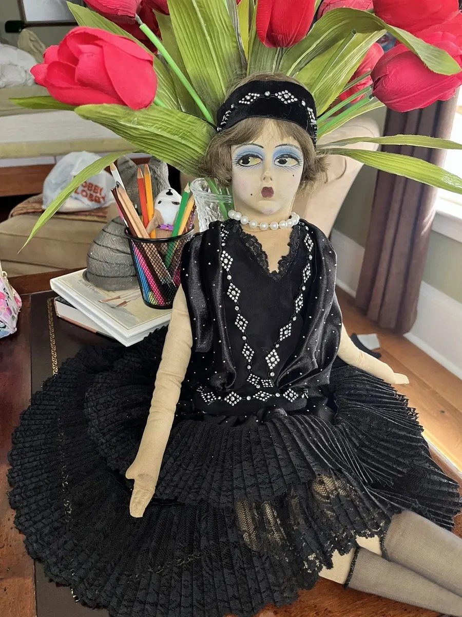 Boudoir Gerling doll seated beside red tulips, full view.